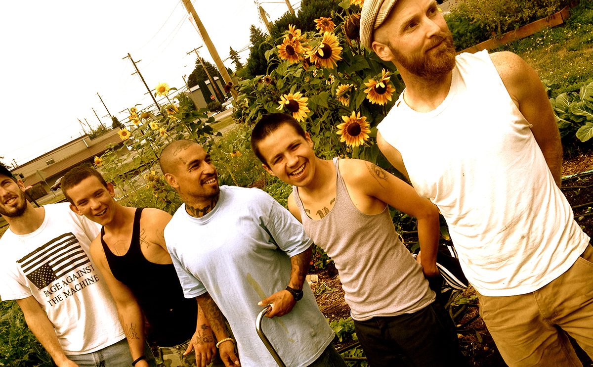 Group of guys holding hands in a Permaculture Garden